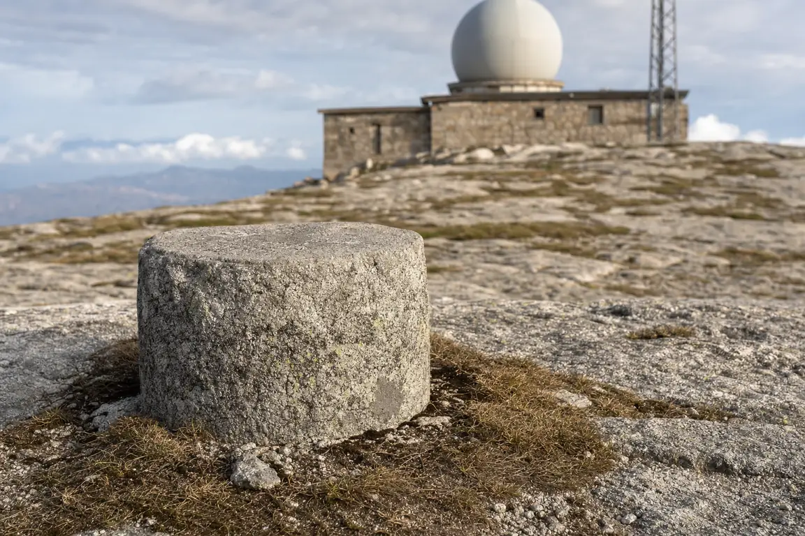 Vermessungsmarke auf dem Gipfelplateau, dahinter der Kuppelbau
