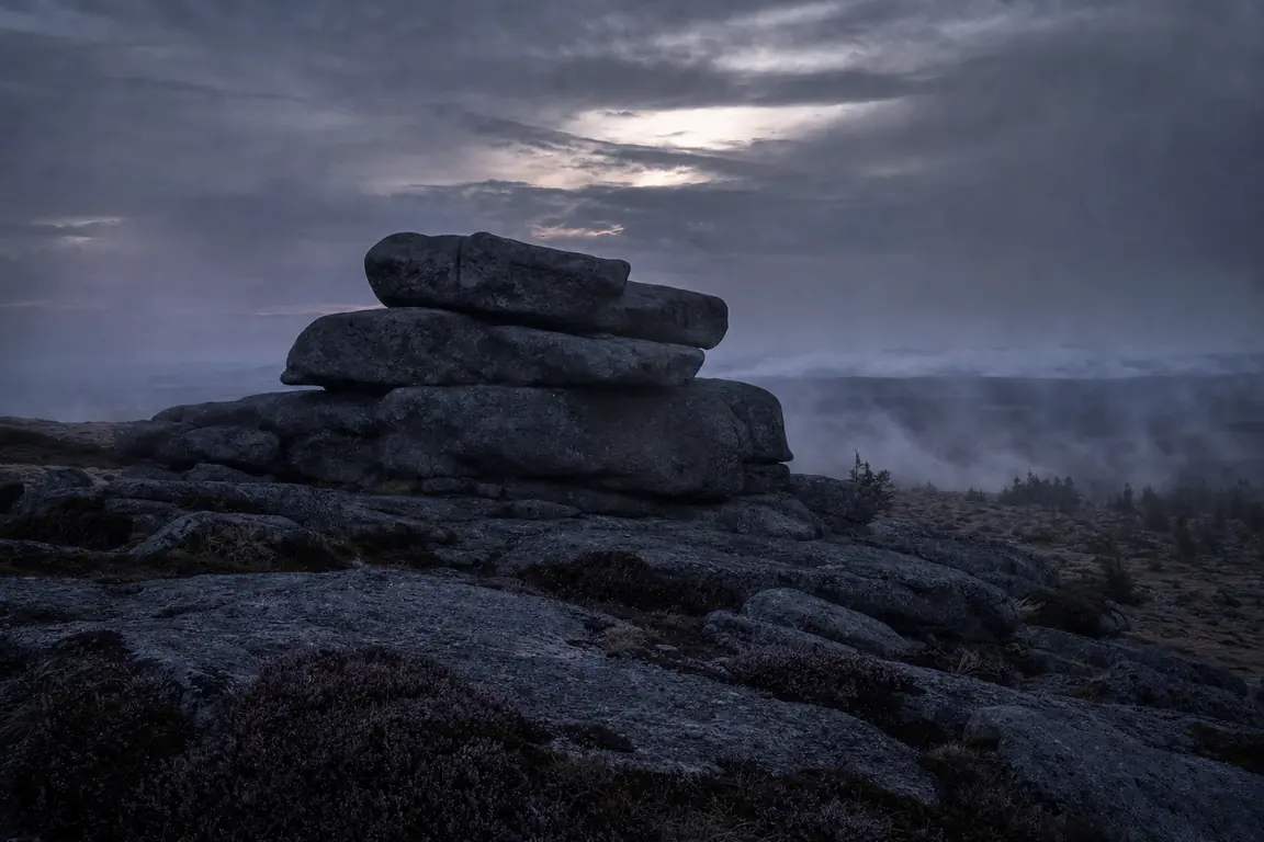 Granitfelsen auf dem Brockenplateau in der Abenddämmerung mit ziehendem Nebel